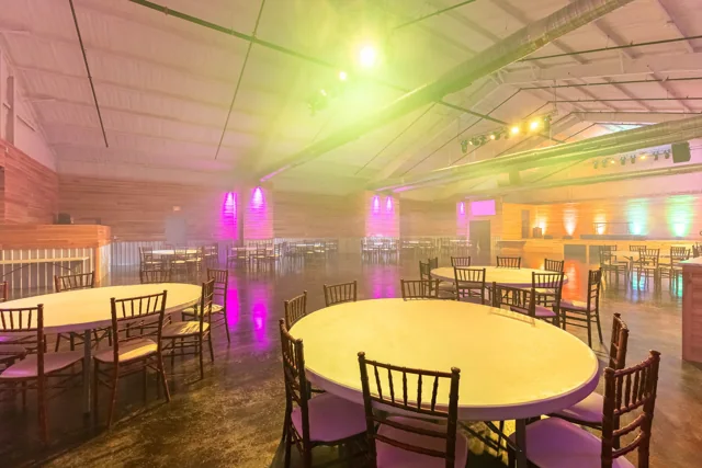 Cocktail tables and colorful lighting inside the event hall