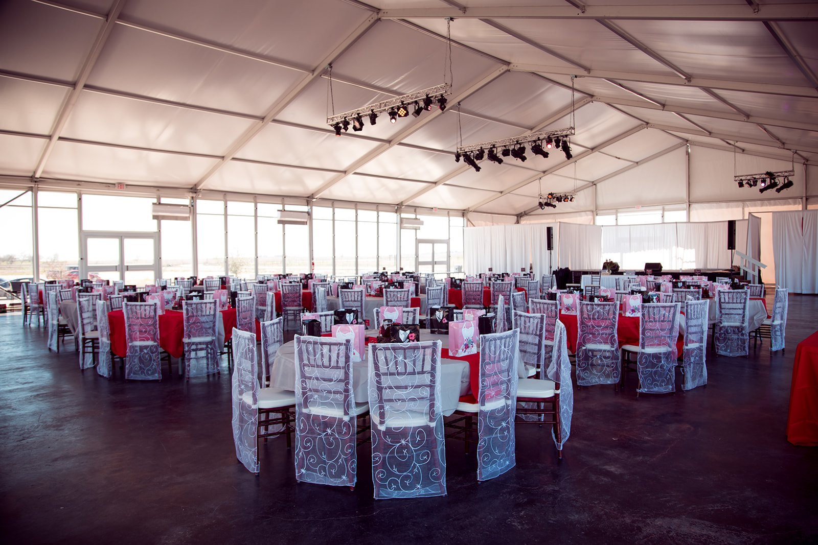 Reception tables with burgundy runners and white chair bands