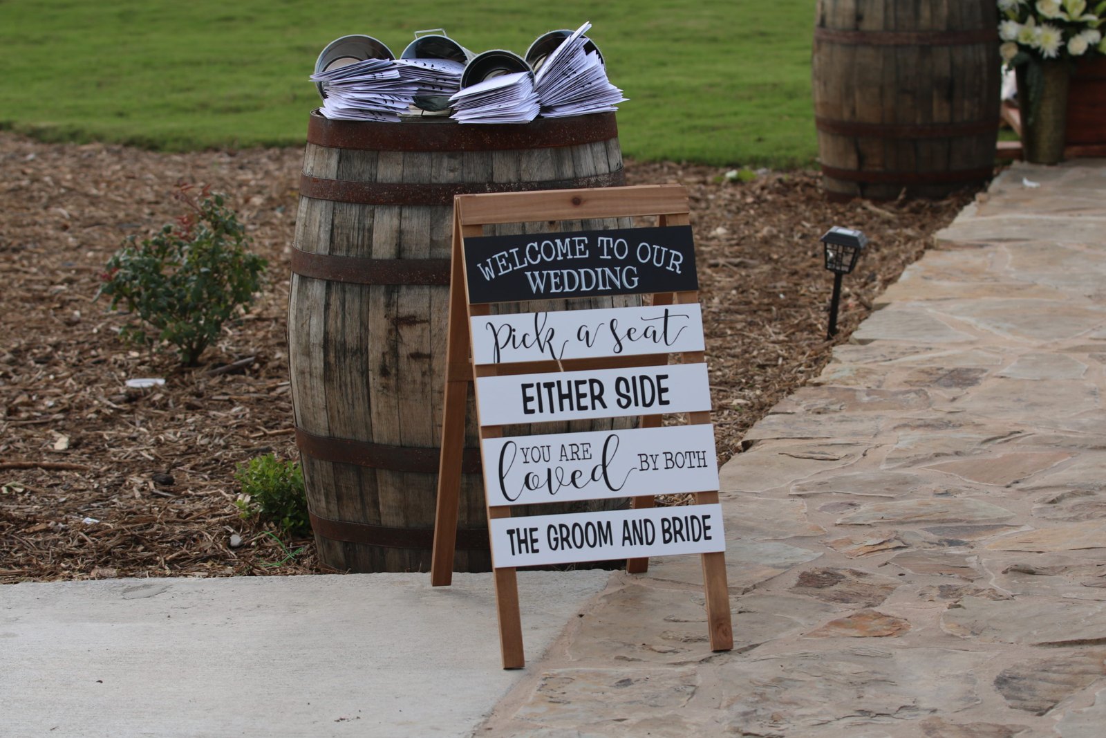 Decorated wedding welcome sign beside the ceremony aisle