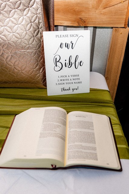 A wedding guest Bible displayed on a green table runner
