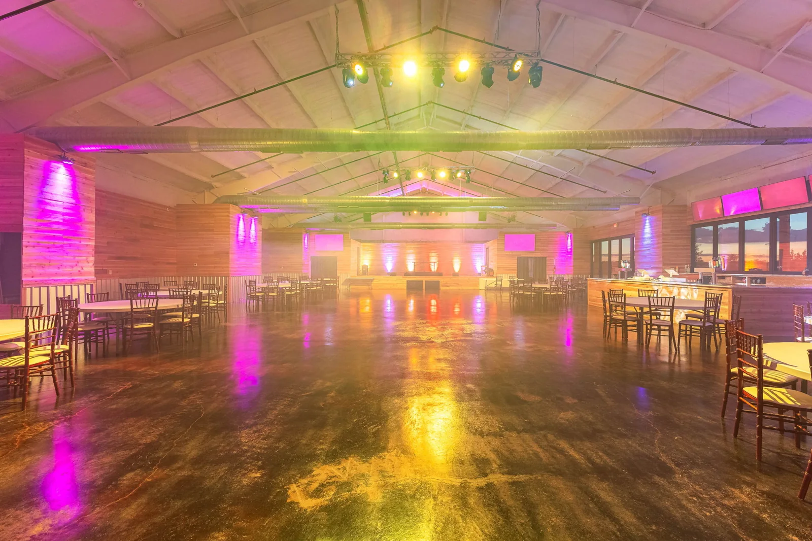 Colorful event lighting fills the Enchanted Ranch indoor hall