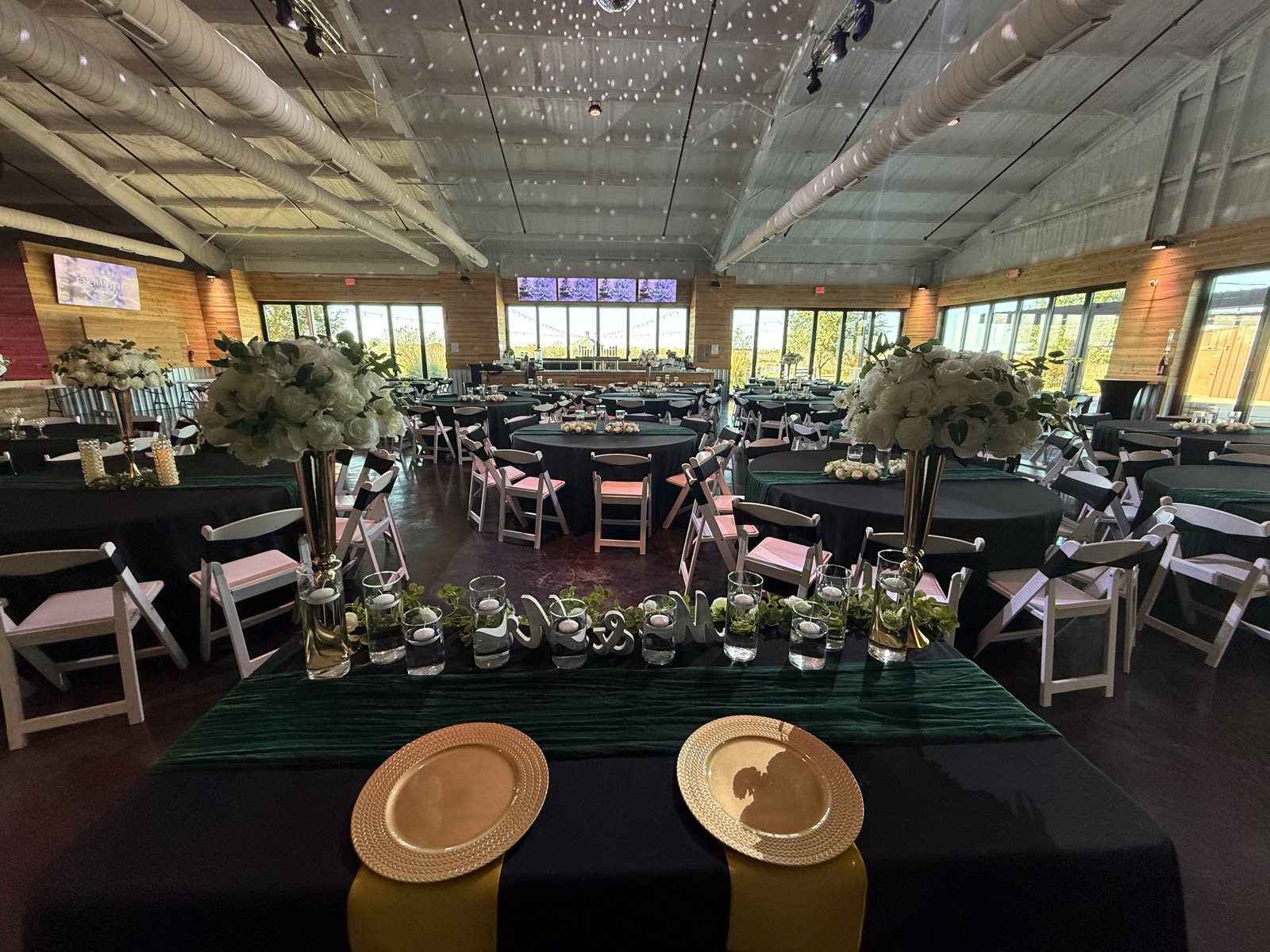 Emerald reception tables beneath white ceiling drapes