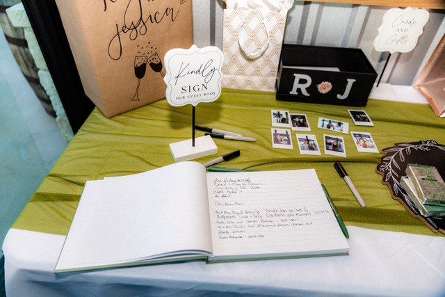 Guest book and card table with sage linen and floral accents