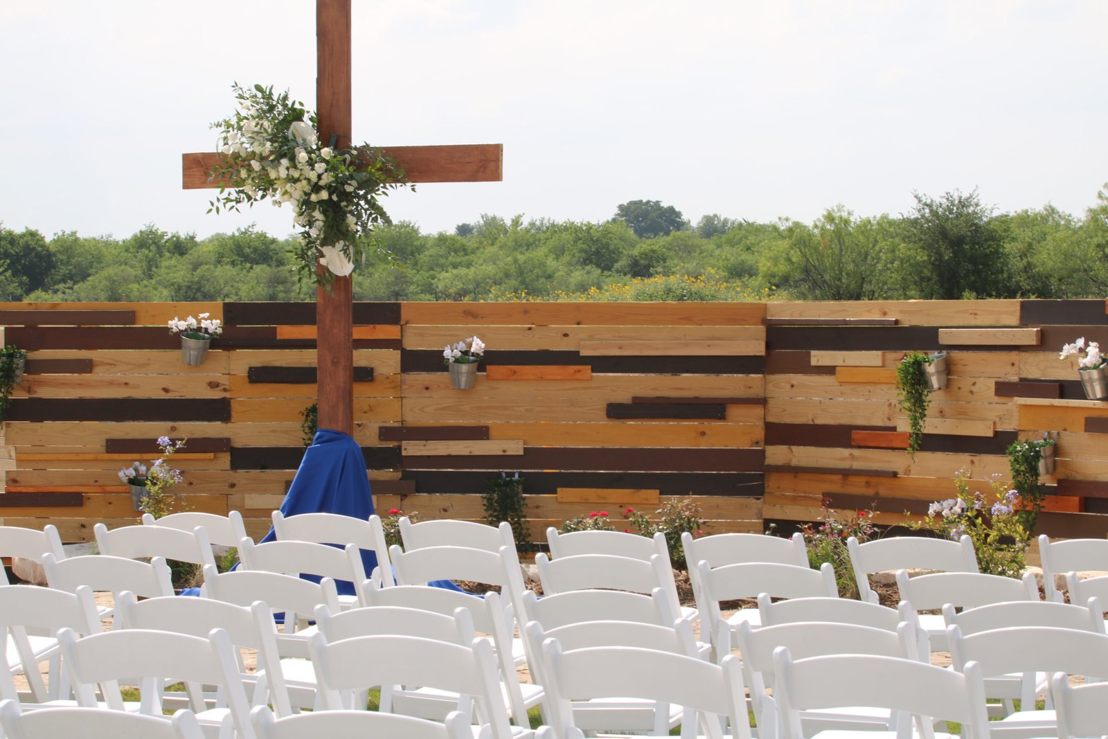 Ceremony cross with white flowers and blue fabric accents