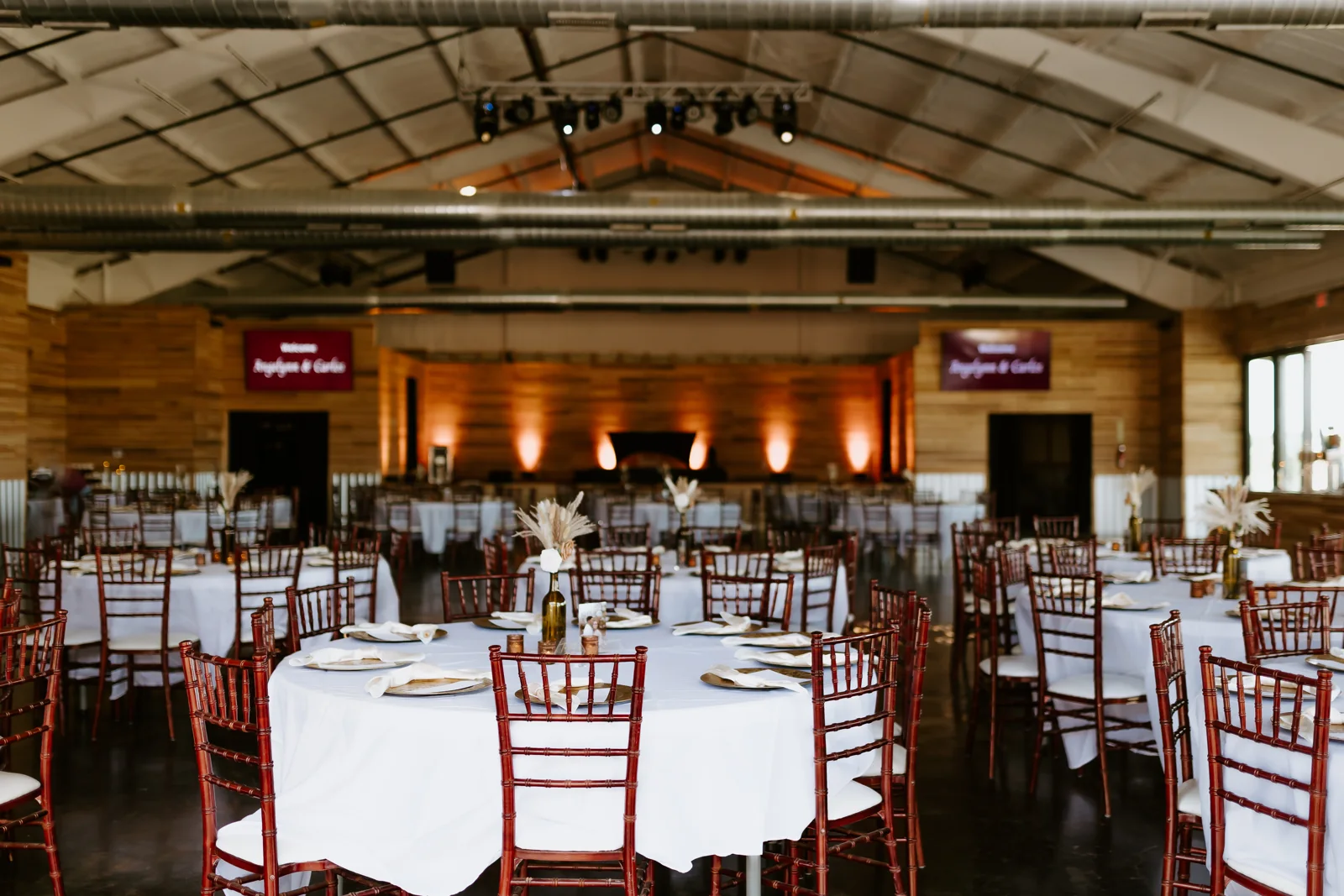 The new Enchanted Ranch event hall with wood-lined walls and tables arranged for a gathering