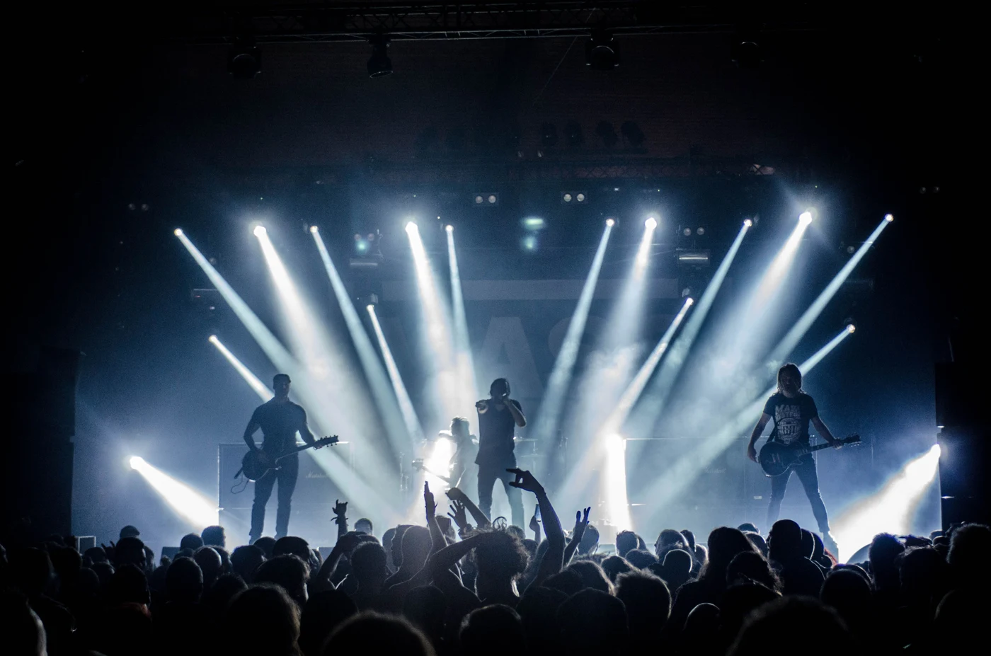 A live band performing before a crowd under bright stage lights