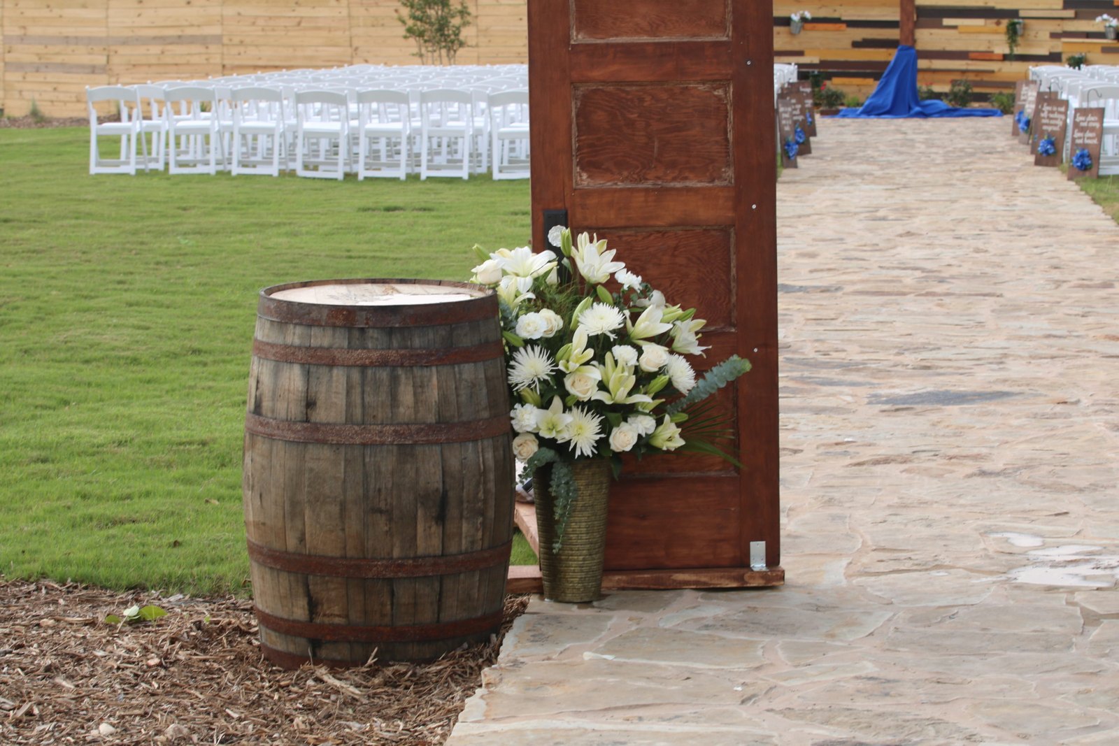 White flowers arranged beside a rustic ceremony barrel