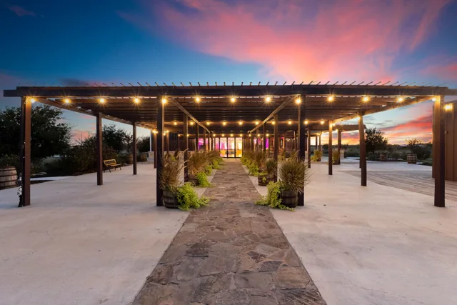 The ranch courtyard and pergola beneath a colorful Texas sunset
