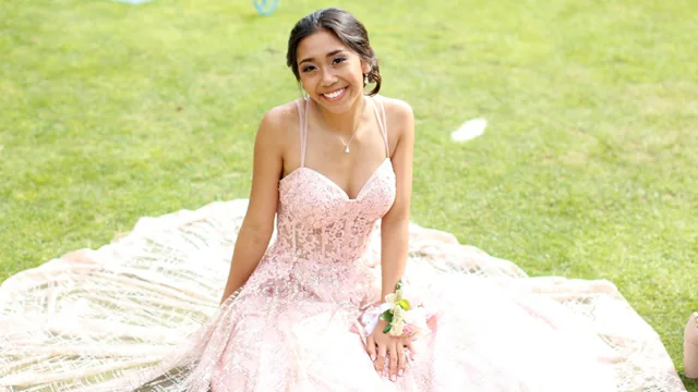 A young woman in a pink celebration dress on the ranch lawn
