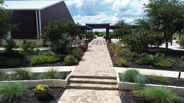 A landscaped stone path leads into the ranch courtyard