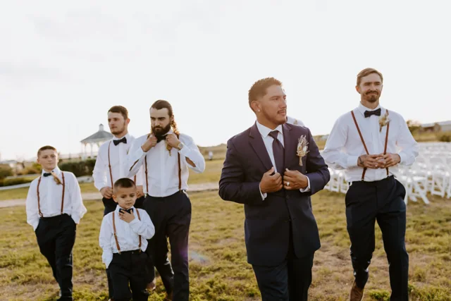 Smiling wedding guests walk through the ranch grounds