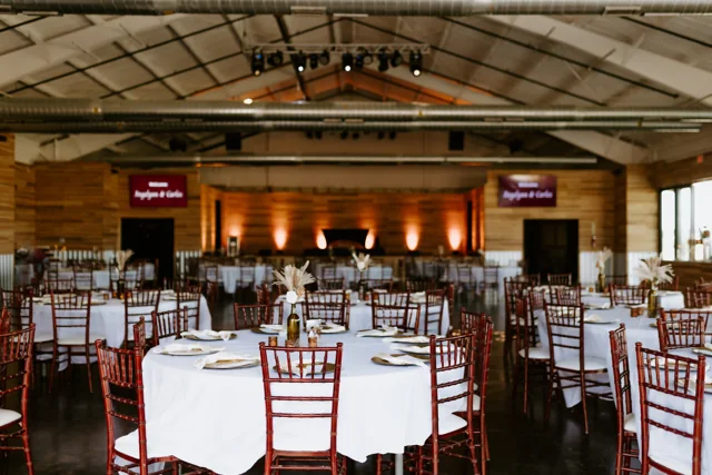 The event hall set with round tables and white linens