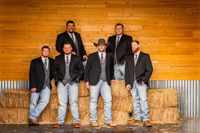 Wedding friends pose together in the ranch reception hall
