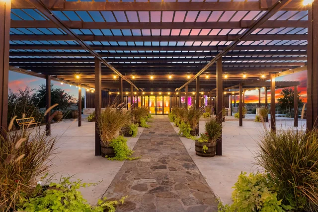 String lights glow above the landscaped pergola walkway