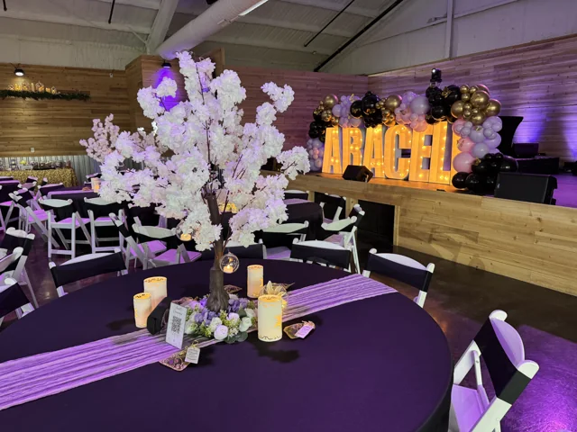 Purple reception décor with flowers and illuminated letters