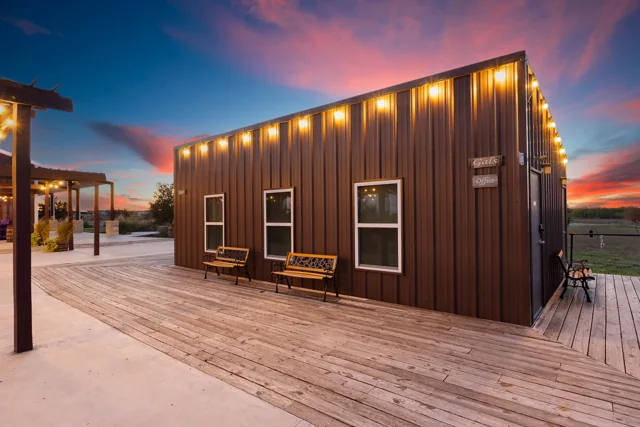 The ranch exterior beneath a pink and blue evening sky