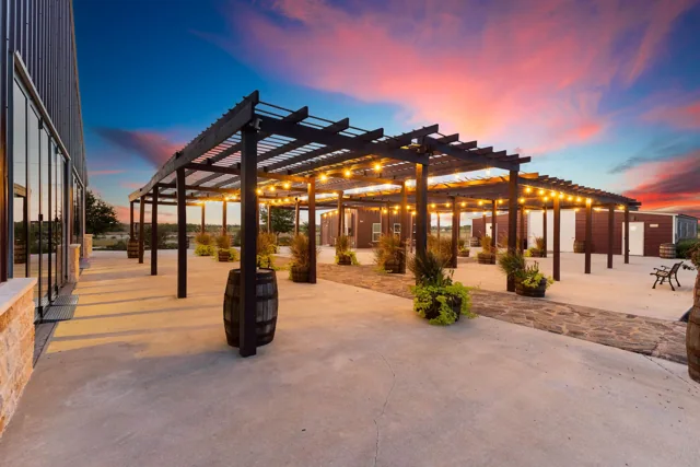 An open pergola framed by glowing string lights at dusk